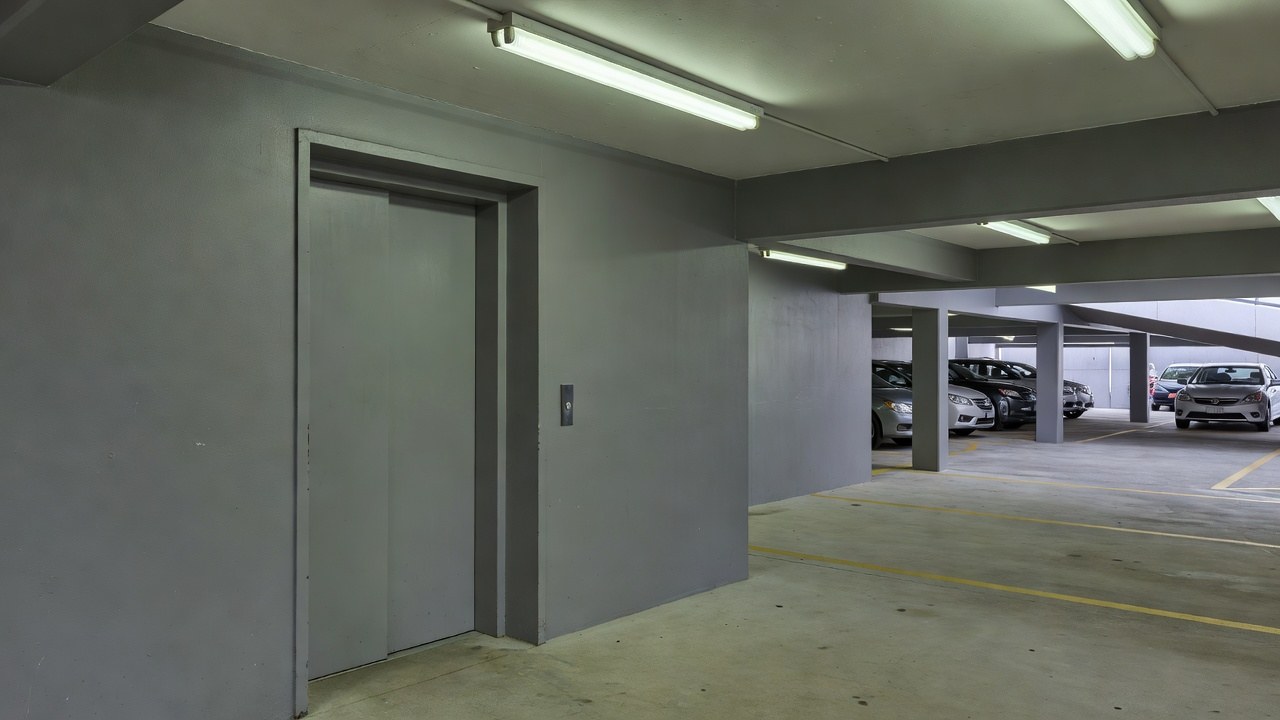 A basement car park lift lobby with a steel fire door beside the lift